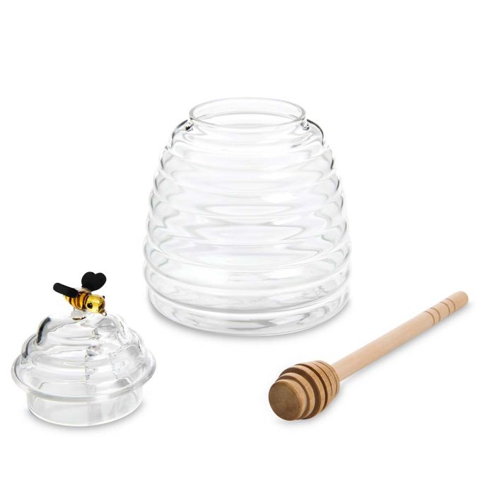Clear glass honeycomb-shaped container with a wooden dipper on a white background